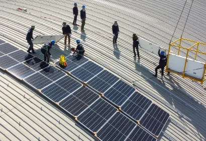 Solar technician working beside photovoltaic panels