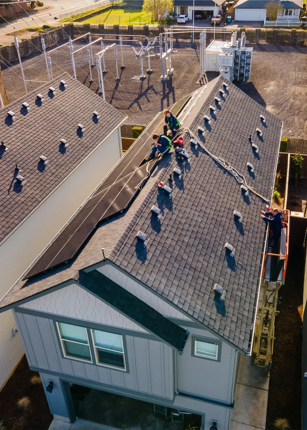 Solar installers setting panels on a residential roof